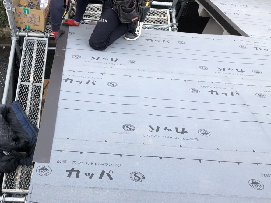 屋根先に水切り板金を施工中