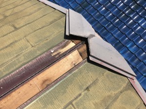 板金がめくれたスレート屋根の一部