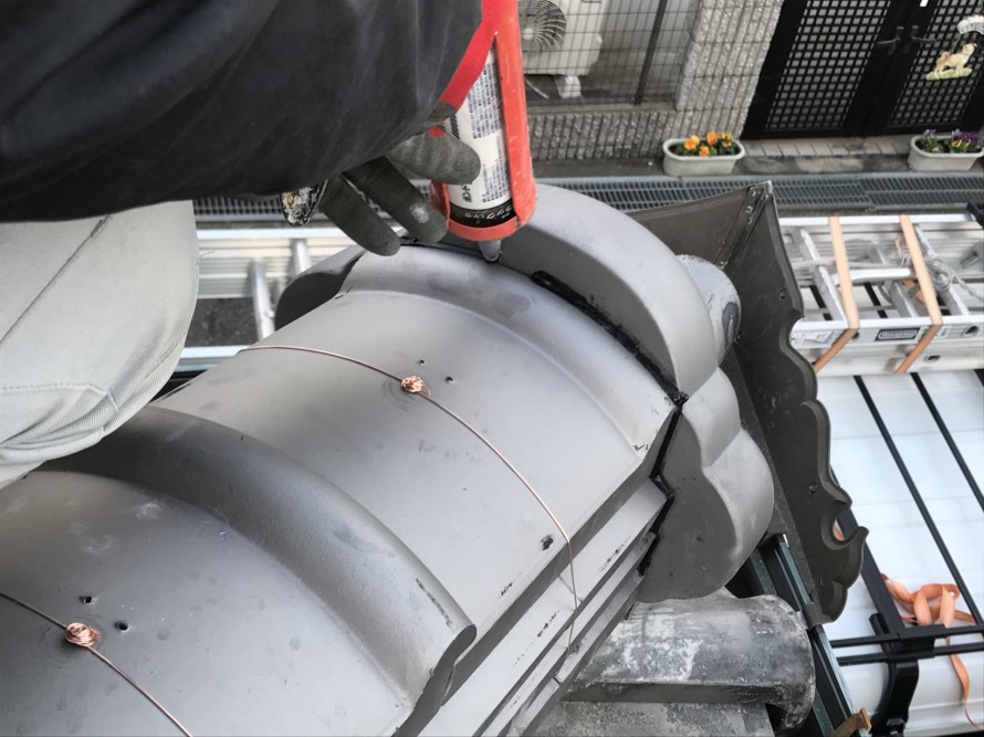 鬼瓦にコーキング施工中