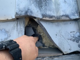 割れた瓦から雨水が入り屋根葺き土を流しています